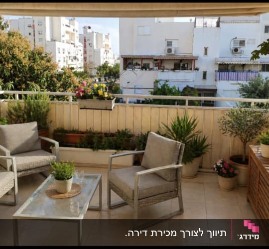 מרפסת עם צמחים וריהוט גן בבניין מגורים